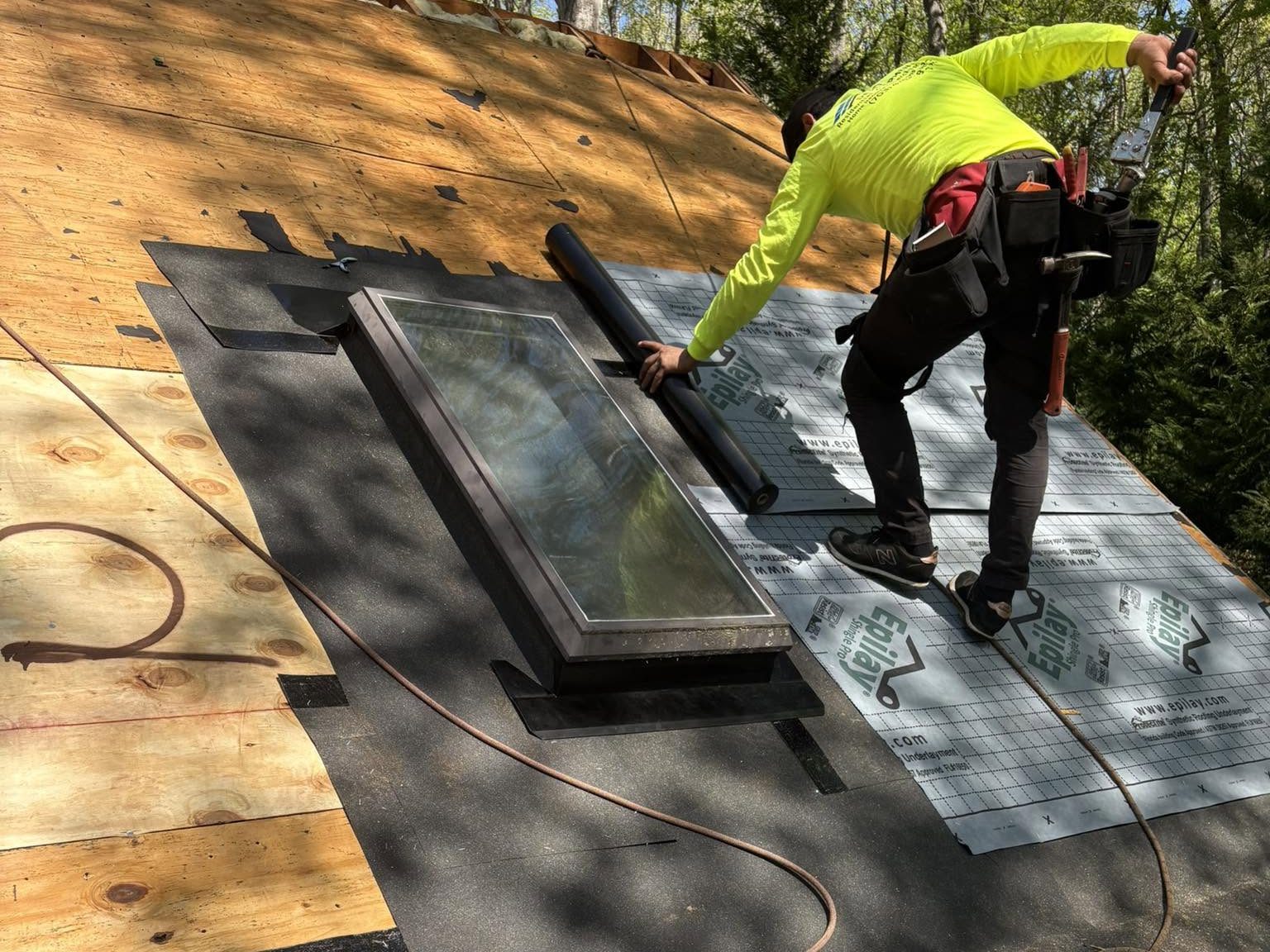 Roofer laying ice and water shield around a skylight on a Mineral roof
