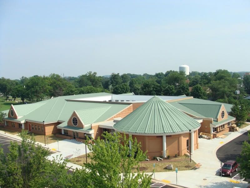 Rust Library in Leesburg with a green standing seam metal roof, including the tapered round section